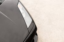 Close-up of black luxury car on pavement on street — Stock Photo