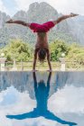 Man standing upside down on pool — Stock Photo