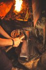 Anonymer Mann schmiedet mit Hummer Klinge aus Metallstück in professioneller Werkstatt — Stockfoto