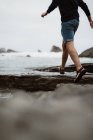 Person running on coastline on sand to sea in Cantabria, Spain — Stock Photo