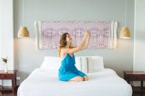 Женщина с помощью смартфона на кровати — стоковое фото