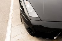 Крупный план черного роскошного автомобиля на тротуаре на улице — стоковое фото