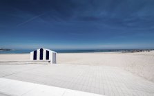 Vista mozzafiato del cielo grigio nuvoloso sulla spiaggia vuota con sabbia bianca. — Foto stock