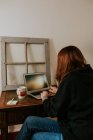 Jovem mulher digitando no laptop na mesa vintage — Fotografia de Stock