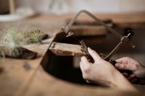 Schnitzhände aus Baumrinde mit Instrument auf dem Schreibtisch? — Stockfoto