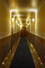 Hall d'hôtel éclairé par des lampes sur les murs — Photo de stock