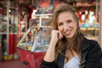 Молода щаслива жінка на вулиці проти магазину розваг — стокове фото
