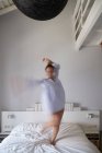 Femme floue sautant sur le lit — Photo de stock