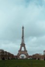 Vista para o gramado verde grande e Torre Eiffel no fundo do céu nublado em Paris, França. — Fotografia de Stock