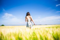 Дівчина стоїть в полі в сонячний день — стокове фото