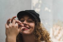 Close-up of young emotionless woman with red lipstick and voluminous curls looking at camera — Stock Photo