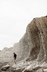 Vue de l'arrière d'un homme marchant entre les montagnes, regardant loin en Cantabrie, Espagne — Photo de stock