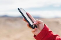Erntehelfer steht mit Smartphone am Geysir — Stockfoto