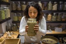 Close-up of Woman smelling jar of spices in spice shop — Stock Photo