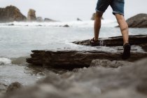 Persona che corre sulla costa dalla sabbia al mare in Cantabria, Spagna — Foto stock