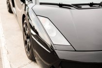 Nahaufnahme von schwarzem Luxusauto auf Gehweg auf der Straße — Stockfoto