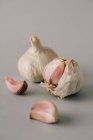 Cloves of fresh garlic on gray background — Stock Photo