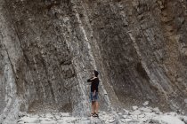 Man looking up to climb on rock — Stock Photo