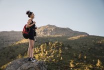 Молода жінка з рюкзаком насолоджується природою в горах — стокове фото