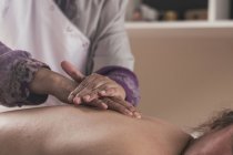 Терапевт робить східний масаж жінці в масажному кабінеті — стокове фото