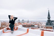 Jeune femme blonde debout sur le toit — Photo de stock