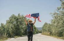 Homem de chapéu mostrando bandeira americana — Fotografia de Stock