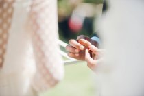 Young man and woman exchanging wedding rings in garden — Stock Photo