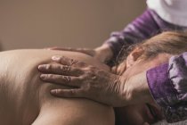 Terapeuta haciendo masaje oriental a mujer en sala de masajes - foto de stock