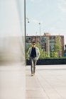 Впевнений елегантний чоловік ходить по місту з руками в кишенях — стокове фото
