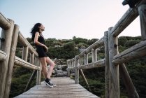 Junge brünette Frau mit angelehnt an Gehweg in der Natur — Stockfoto
