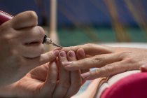 Maniküre-Frau poliert Nägel der Kundin mit Spezialwerkzeug im Schönheitssalon — Stockfoto