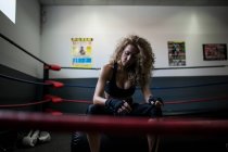 Mulher fitness em roupas esportivas enrolando bandagem de boxe — Fotografia de Stock