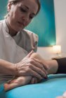 Therapist massaging female foot in massage room — Stock Photo