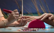 Unhas de polimento manicure femininas do cliente com ferramenta especial no salão de beleza — Fotografia de Stock