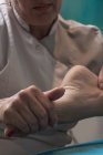 Терапевт масажує жіночу ногу в масажному кабінеті — стокове фото