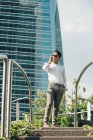 Selbstbewusster junger Geschäftsmann spricht auf dem Smartphone Stufen hinunter — Stockfoto