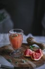 Fresh grapefruit juice in glass with ingredient on kitchen table — Stock Photo