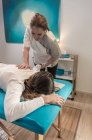 Terapeuta haciendo tratamiento corporal para estimular problemas corporales en la sala de masajes - foto de stock