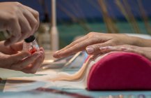 Manicura femenina pintando uñas de cliente en salón de belleza - foto de stock