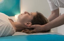 Therapeut massiert weibliches Gesicht im Massageraum — Stockfoto