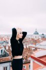 Junge blonde Frau steht auf dem Dach — Stockfoto