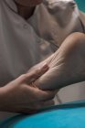 Thérapeute masser les pieds féminins dans la salle de massage — Photo de stock