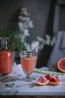 Zumo de pomelo fresco en vaso sobre mesa de mármol blanco - foto de stock