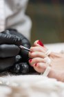 Female manicurist doing pedicure to client with special tool in beauty salon — Stock Photo