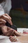 Manicurista femminile che archivia unghie di piedi di cliente in salone di bellezza — Foto stock
