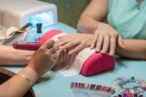 Unhas de polimento manicure femininas do cliente com ferramenta especial no salão de beleza — Fotografia de Stock