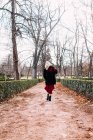 Jovem mulher em vestido vermelho andando no parque — Fotografia de Stock