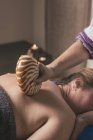 Terapeuta fazendo massagem oriental com concha na sala de massagem — Fotografia de Stock