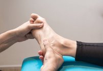 Терапевт массирует женскую ногу в массажном кабинете — стоковое фото