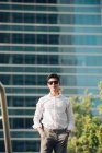 Fiducioso giovane uomo d'affari in piedi di fronte all'edificio moderno — Foto stock
